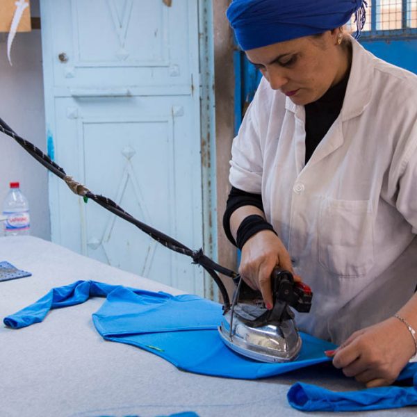 Africa, Tunisia, Gafsa. Hedia is the owner of Marn-Tex Textile garment factory, a supplier to Benetton clothing. She started this factory in 2010, the name is a mix of her kids’ names. “I got my diploma in textile tech in 1983. I worked as a teacher in design in Gafsa but once I got married and had children it was cheaper to stay home and take care of them. I started a little textile business that grew as Benetton took me on as a supplier. As a woman it was difficult supervising men, so I hire mostly women. Women are more serious workers and I trust them more. There are about 120 workers here and about 20 are men. Most of the workers make about $400 dinar ($160) a month. The workers have the option to stay later or work Saturdays to work overtime. If someone always stays late they get a bonus. Everyone has to take Sundays off.”
Hedia never stops smiling and everyone seems to love her. She obviously cares deeply about her employees. She has hired about 14 workers with disabilities, including a few that are deaf. She even went overseas for a year to study sign language so she could communicate with them.